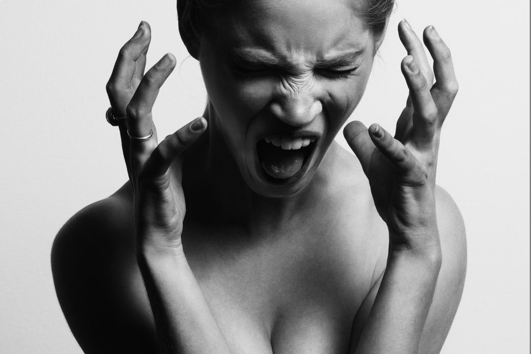 A black-and-white image of a woman stressed about the fact that she is having to spend so long rewriting her AI-generated content in order to get results